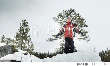 Boy standing in snow with arms outstretched 11635840
