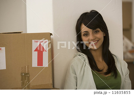 Woman sitting next to moving box Woman sitting next to moving box 11635855
