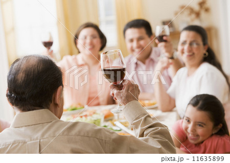 Hispanic family toasting at dinner table Hispanic family toasting at dinner table 11635899