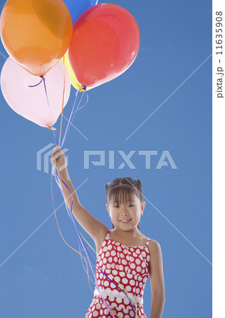 Asian girl holding bunch of balloons 11635908