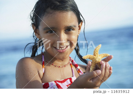 Hispanic girl holding starfish 11635912