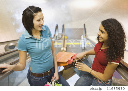 Multi-ethnic teenage girls holding shopping bags 11635930