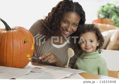 Portrait of mother and daughter carving pumpkin 11635948