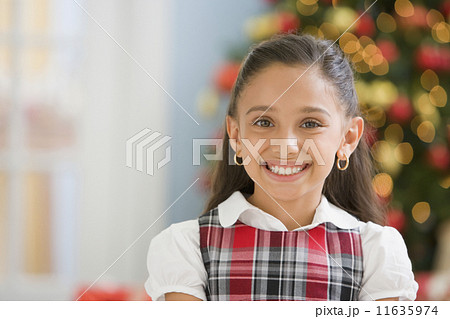 Hispanic girl in front of Christmas tree 11635974
