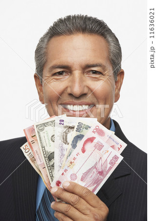 Hispanic businessman holding assorted world currencies 11636021