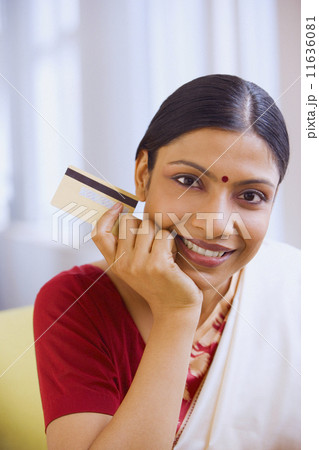 Indian woman in traditional clothing holding credit card 11636081