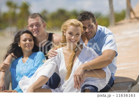 Multi-ethnic couples hugging at beach 11636163