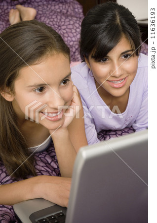 Multi-ethnic girls looking at laptop 11636193