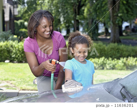 African mother and young daughter washing car 11636201