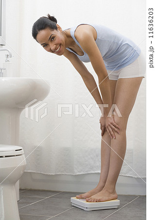 African woman standing on bathroom scale 11636203