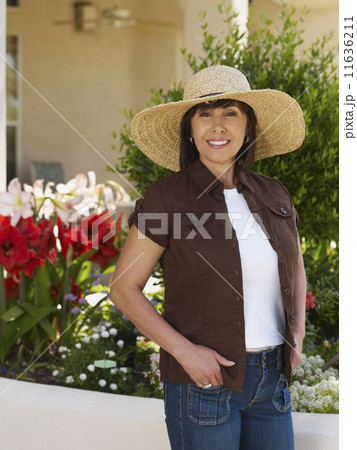 Hispanic woman wearing sunhat 11636211