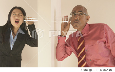 Business people listening through wall with glass to ear 11636230