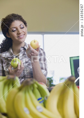 Mixed Race woman choosing apples at grocery store Mixed Race woman choosing apples at grocery store 11636287