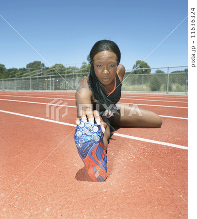 Female track athlete stretching 11636324