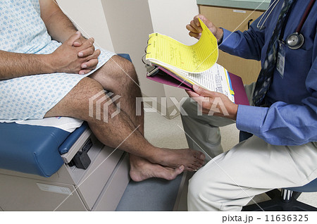 Low section of male doctor with patient 11636325