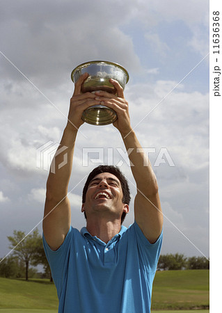 Hispanic man holding golf trophy over head Hispanic man holding golf trophy over head 11636368