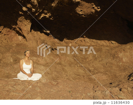 Senior Hispanic woman meditating 11636430