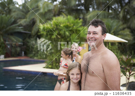 Family hugging next to swimming pool 11636435