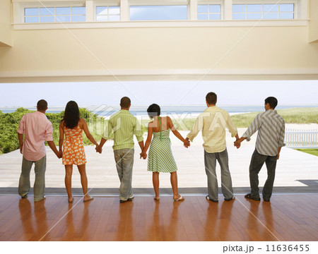 Multi-ethnic friends holding hands at beach resort 11636455