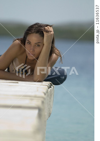 Young woman laying on dock Young woman laying on dock 11636537