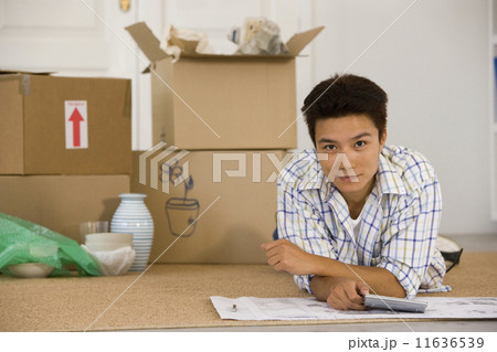 Asian man next to unpacked moving boxes 11636539