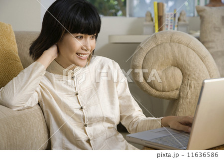 Asian woman looking at laptop 11636586