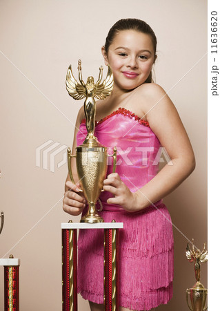 Mixed Race girl holding dancing trophy 11636620