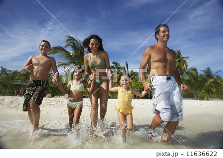 Hispanic family running into water Hispanic family running into water 11636622