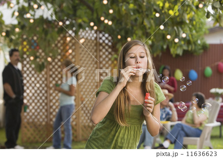 Hispanic girl blowing bubbles 11636623