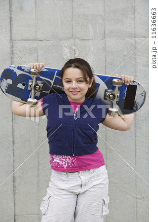 Mixed Race girl holding skateboard Mixed Race girl holding skateboard 11636663