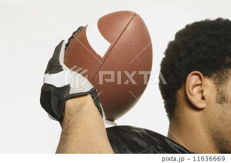 African American man holding football 11636669