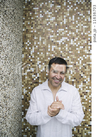 Hispanic man in front of tile wall 11636703