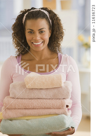 African woman carrying stack of towels 11636723