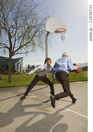 Two businessmen playing basketball  11636731
