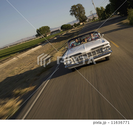 Multi-ethnic friends driving in low rider car 11636771