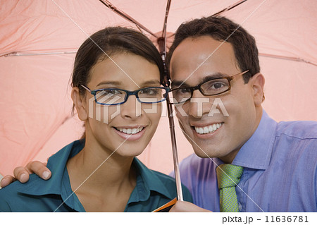 Hispanic couple standing under umbrella Hispanic couple standing under umbrella 11636781