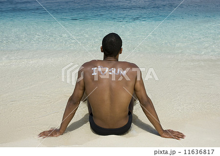 Hispanic man sitting on beach 11636817