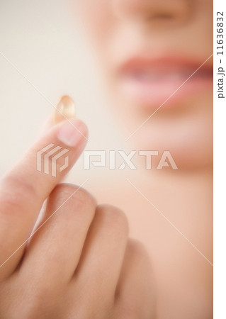 Close up of fingers holding vitamin 11636832