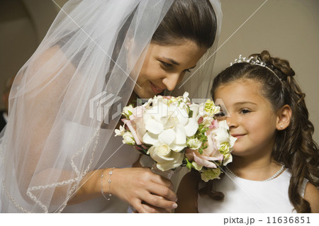 Hispanic bride and young girl smelling flowers Hispanic bride and young girl smelling flowers 11636851