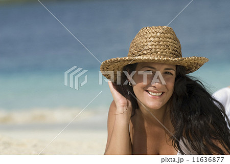 Hispanic woman wearing straw hat 11636877
