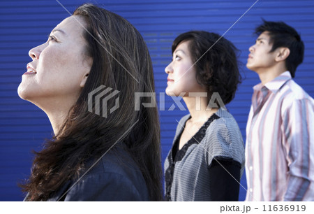 Profile of three Asian people looking up 11636919