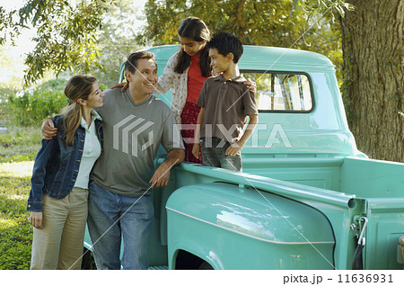 Multi-ethnic family in back of truck Multi-ethnic family in back of truck 11636931