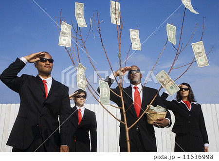 Multi-ethnic businesspeople saluting money tree Multi-ethnic businesspeople saluting money tree 11636998