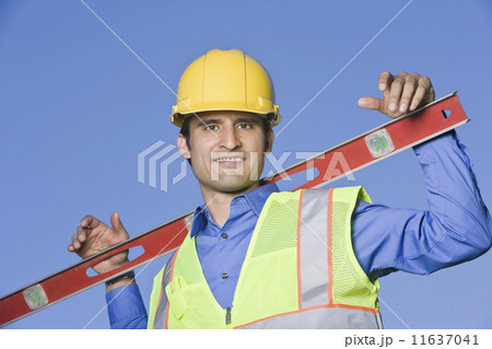 Hispanic construction worker holding level Hispanic construction worker holding level 11637041
