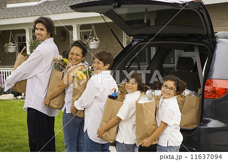 Hispanic family unloading grocery bags from car Hispanic family unloading grocery bags from car 11637094