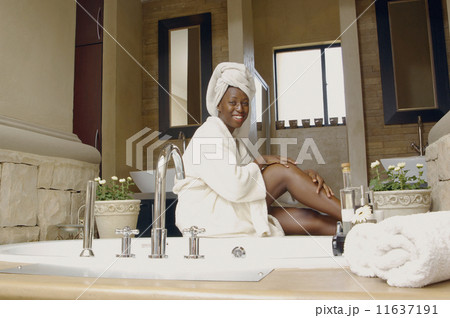 African American woman in bathroom wearing bathrobe 11637191