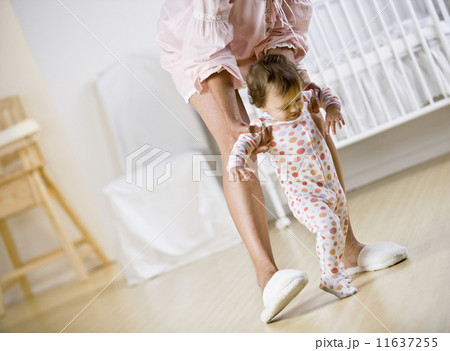 Hispanic mother helping baby walk 11637255