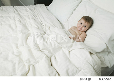Baby laying under bed covers 11637282