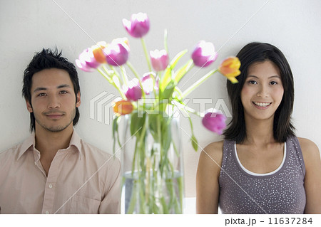 Asian couple next to flowers in vase 11637284