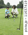 Mother teaching son to play golf 11637419